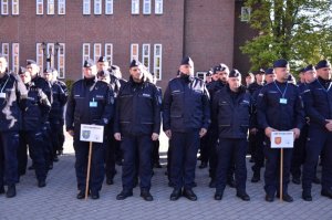 Policjanci stoją na placu - widok na policjantów reprezentujących garnizon śląski.