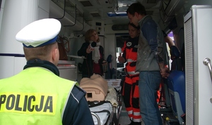 Ratownicy medyczni i dziennikarz wewnątrz karetki pogotowia ratunkowego