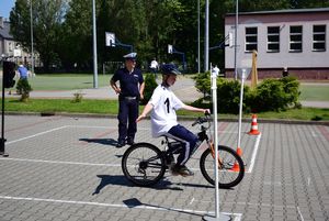 Uczestnik turnieju w trakcie konkurencji, jazda na rowerze w miasteczku ruchu drogowego.