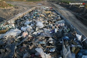Zdjęcie przedstawia  nielegalnie składowane różnego rodzaju odpady