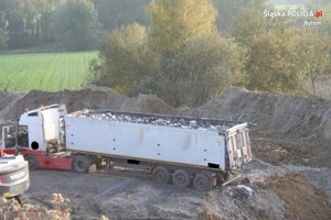 Zdjęcie przedstawia samochód ciężarowy wysypujący odpady niezgodnie z przepisami