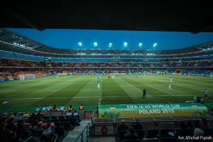 płyta boiska stadionu w Bielsku Białej podczas meczu, widoczni piłkarze, część trybun i kibice