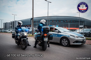 Policjanci na motocyklach przed katowickim spodkiem, w tle radiowóz