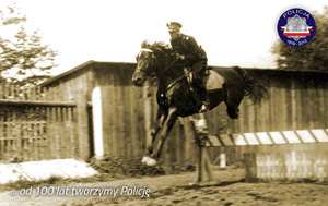 Zdjęcie archiwalne z okresu międzywojennego: policjant na koniu podczas skoku przez przeszkodę