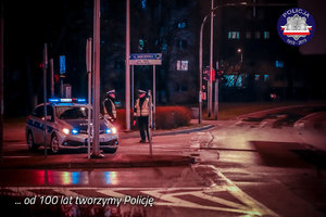 Policjanci ruchu drogowego przy radiowozie nocą