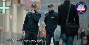 Policjanci na patrolu - jeden z policjantów używa krótkofalówki