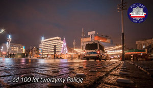Radiowóz policyjny nocą na katowickiej ulicy - w tle odświętna dekoracja miasta