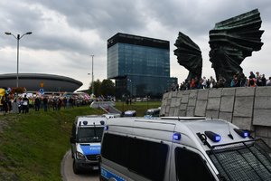 Policyjne radiowozy na tle Spodka i Pomnika Powstańców Śląskich
