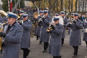 Zdjęcie kolorowe, przedstawiające przemarsz orkiestry policyjnej.