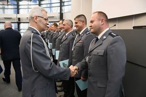 Zdjęcie kolorowe. Zastępca Komendanta Wojewódzkiego Policji w Katowicach inspektor Mariusz Krzystyniak składa gratulacje policjantowi