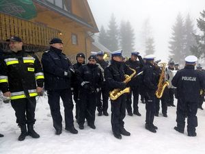 Uczestnicy akcji stojący obok policyjnej orkiestry