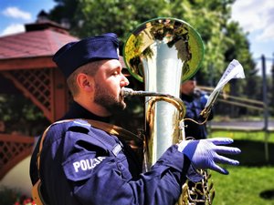 Policjant z orkiestry gra na instrumencie muzycznym.