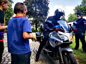 Dzieci przyglądają się policjantom na motocyklach.
