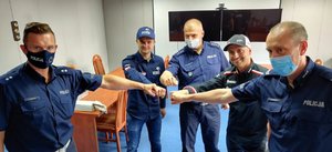 Zdjęcie kolorowe. Kajetan Kajetanowicz, Maciej Giemza i trzej policjanci Wydziału Ruchu Drogowego