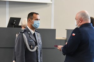 Zdjęcie kolorowe. Komendant Wojewódzki Policji wręcza medal za długoletnią służbę