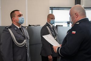 Zdjęcie kolorowe. Komendant Wojewódzki Policji wręcza mianowanie na wyższy stopień