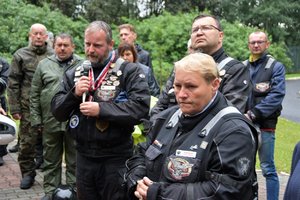 Uczestnicy wydarzenia stoją przed Grobem Policjanta Polskiego. Prezes fundacji przemawia.