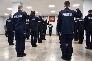 Policjanci sfotografowani stojąc tyłem, w tle przemawiający Komendant Wojewódzki Policji w Katowicach.
