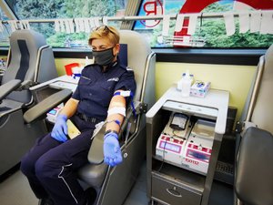 Zdjęcie kolorowe. Policjantka w trakcie pobierania krwi.