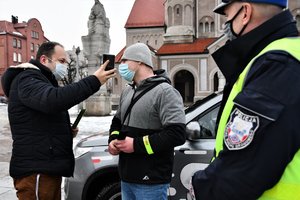 Reporter Radia Express prowadzi wywiad z mężczyzną spotkanym na ulicy, obok stoi umundurowany policjant.