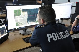 Policjant pracujący przed monitorem komputerowym