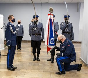Zdjęcie kolorowe. Widoczni umundurowani policjanci, w tym nadinsp. Krzysztof Justyński i insp. Roman Rabsztyn
