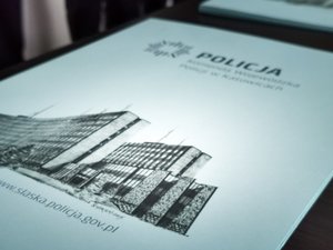 Teczka z grafiką budynku Komendy Wojewódzkiej Policji w Katowicach.
