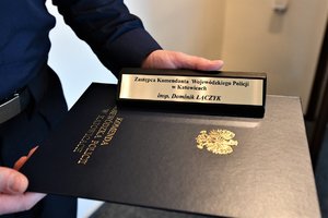 Tabliczka na biurko, na której widnieje napis Zastępca Komendanta Wojewódzkiego Policji w Katowicach insp. Dominik Łączyk.
