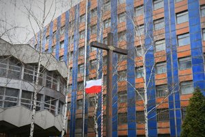 Zdjęcie kolorowe. Widoczny krzyz oraz flaga polska