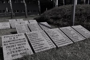 Zdjęcie czarno-białe. Widocze tablice z imionami i nazwiskami oraz wiekiem policjantów zamordowanych przez NKWD
