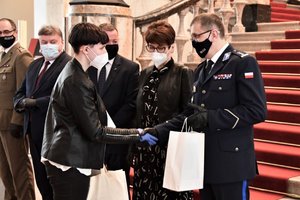 Komendant Wojewódzki Policji w Katowicach wręcza nagrodę laureatce konkursu i jej gratuluje.