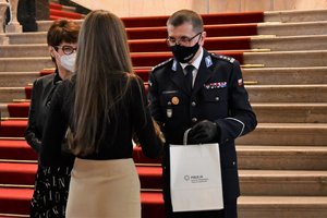 Komendant Wojewódzki Policji w Katowicach wręcza nagrodę osobie wyróżnionej w konkursie.