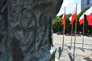 Data 1921, która znajduje się na Pomniku Powstańców Śląskich, w tle powiewające na wietrze flagi Polski.