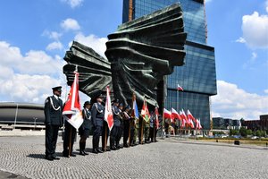 Poczty sztandarowe przedstawicieli służb mundurowych na tle Pomnika Powstańców Śląskich.