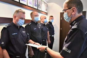 Komendant Wojewódzki Policji w Katowcach wręcza policjantowi rozkaz o powołaniu na stanowisko.