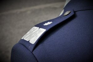 Zdjęcie kolorowe. Widoczne ramie umundurowanego policjanta wraz z naramiennikiem oznaczającym stopień nadinspektora
