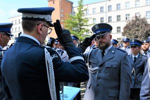 Komendant gratuluje wyróżnionemu policjantowi.