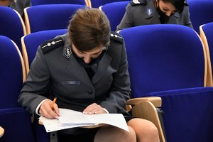 Zdjęcie kolorowe. Dwie policjantki podczas pisania egzaminu oficerskiego.
