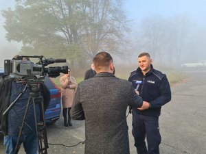 Dziennikarze przeprowadzają wywiad z policjantem