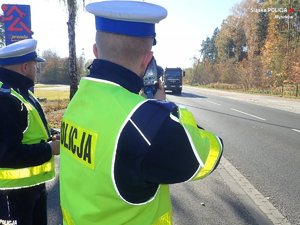 Policjanci kontrolują prędkość z laserowym miernikiem pomiaru prędkości.