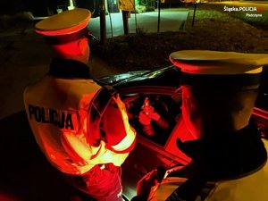 Dwóch policjantów podczas wieczornej kontroli pojazdu.