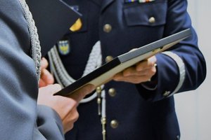 Generał przekazuje pamiątkową ramkę z uroczystości komendantowi z Raciborza.