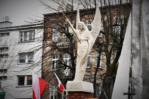Pomnik anioła wolności oraz flagi Polski.