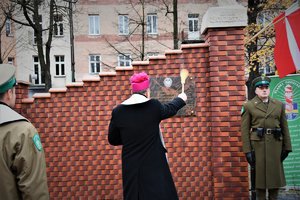 Kolorowe zdjęcie pokazuje moment święcenia tablicy przez biskupa.