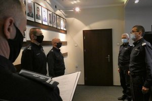 Zdjęcie kolorowe. Widoczni umundurowani policjanci biorący udział w spotkaniu kadrowym w sali portretowej w KWP w Katowicach