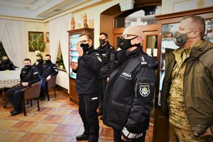 Zdjęcie kolorowe. Widoczni umundurowani policjanci w sali, w tym Zastępca Komendanta Wojewódzkiego