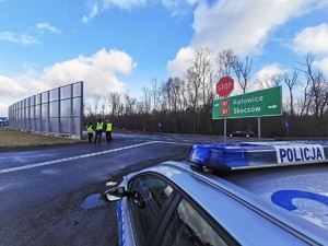 Widoczni policjanci i uczestnicy działań podczas kontroli autokarów przy autostradzie DK 81 w Ochabach Małych (zjazd na Wiślicę)