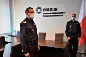 Zdjęcie kolorowe. Widoczni umunudrowani policjanci biorący udział w spotkaniu kadrowym w sali portretowej Komendy Wojewódzkiej Policji w Katowicach