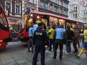 Zdjęcie kolorowe. Widoczni policjanci na przystanku komunikacji miejskiej terenie Katowic