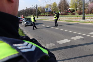 Na fotografii widać dwóch policjantów wydziału ruchu drogowego dokonujących kontrolu stanu trzeźwości kierujących.